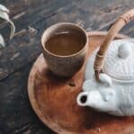 white and brown ceramic teapot on wooden tray