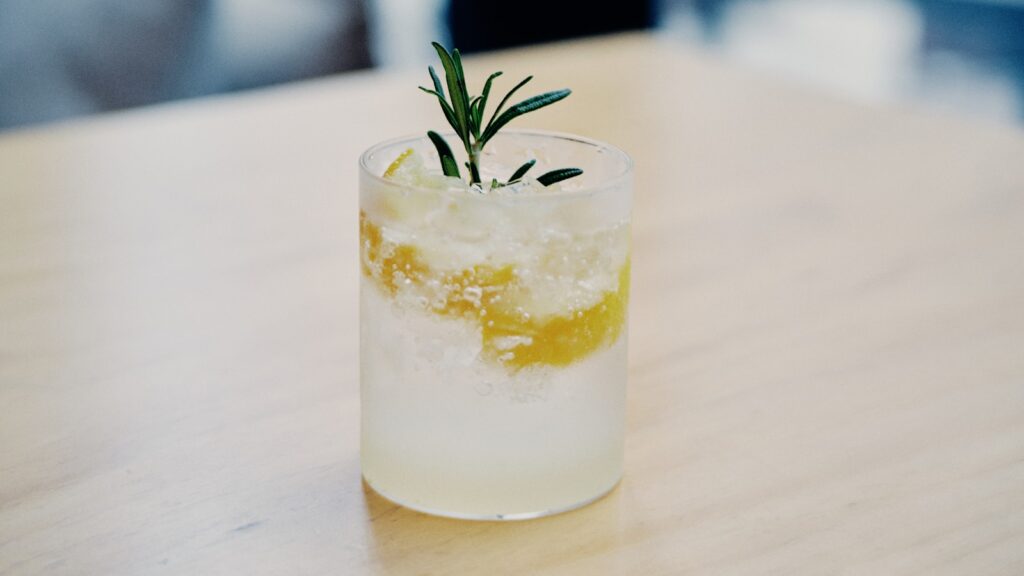 clear drinking glass with white liquid and green leaf